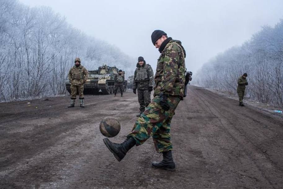 Soldati ucraini e miliziani filorussi che giocano a pallone, ciascuno nel proprio 